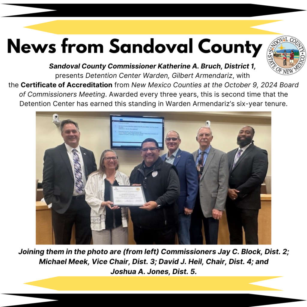 Sandoval County Commissioner Katherine Bruch presents Detention Center Warden Gilbert Armendariz with the Certificate of Accreditation