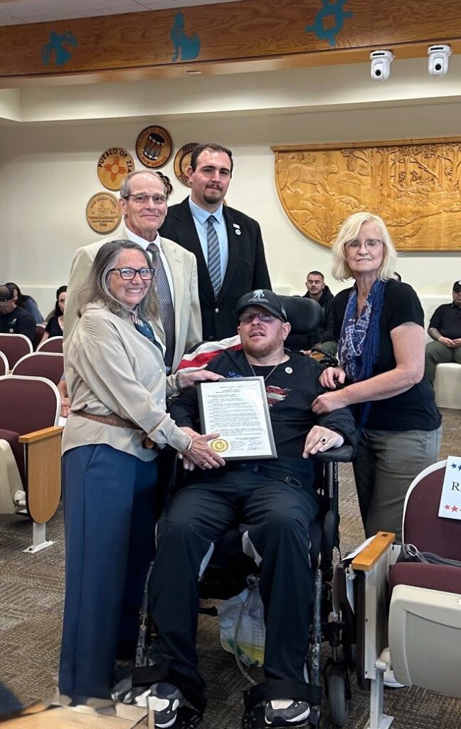 Eric Schei, Wounded Warrior, Army Veteran, with his mother, Christine Schei, and Commissioners (from left) Katherine A. Bruch, Jordan Juarez, and Michael Meek.