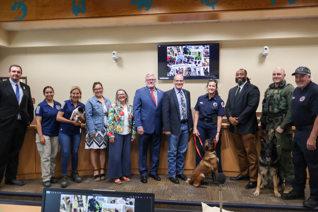 Vice Chair Jordan Juarez, District 4; Animal Care Associates Karol Mata and Kim Jaramillo; Community Services Director Jayme Espinoza; Commissioner Katherine A. Bruch, District 1; Commissioner Jon Herr, District 2; Chair Michael Meek, District 3; Fire & Rescue Captain Shannon Farrell and K9 Mini; Commissioner Joshua Jones, District 5; Sheriff's Office Sergeant Luke Osborn; Fire & Rescue Handler David Farrell, and K9 Shamus