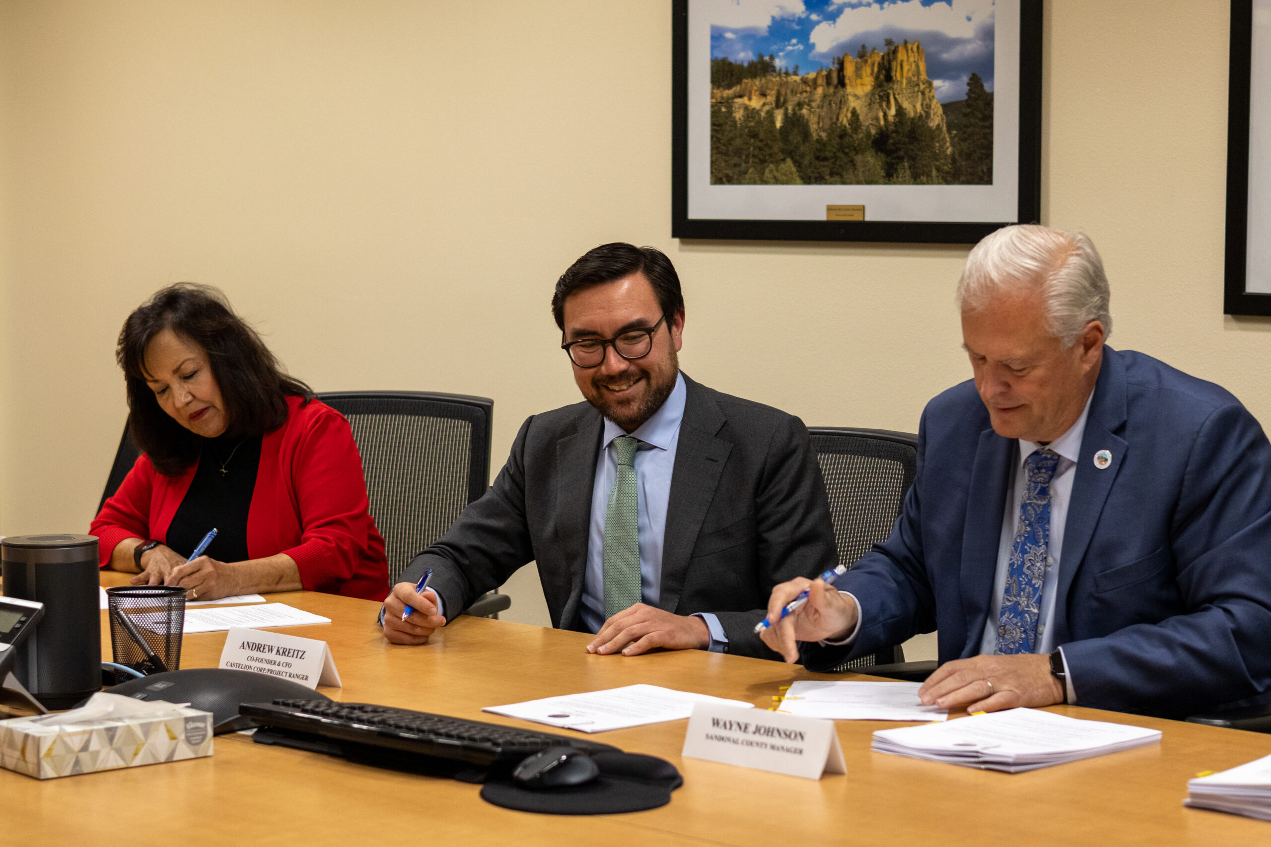 Sandoval County Clerk Anne Brady-Romero, Castelion co-founder and CFO Andrew Kreitz, and Sandoval County Manager Wayne Johnson signing papers