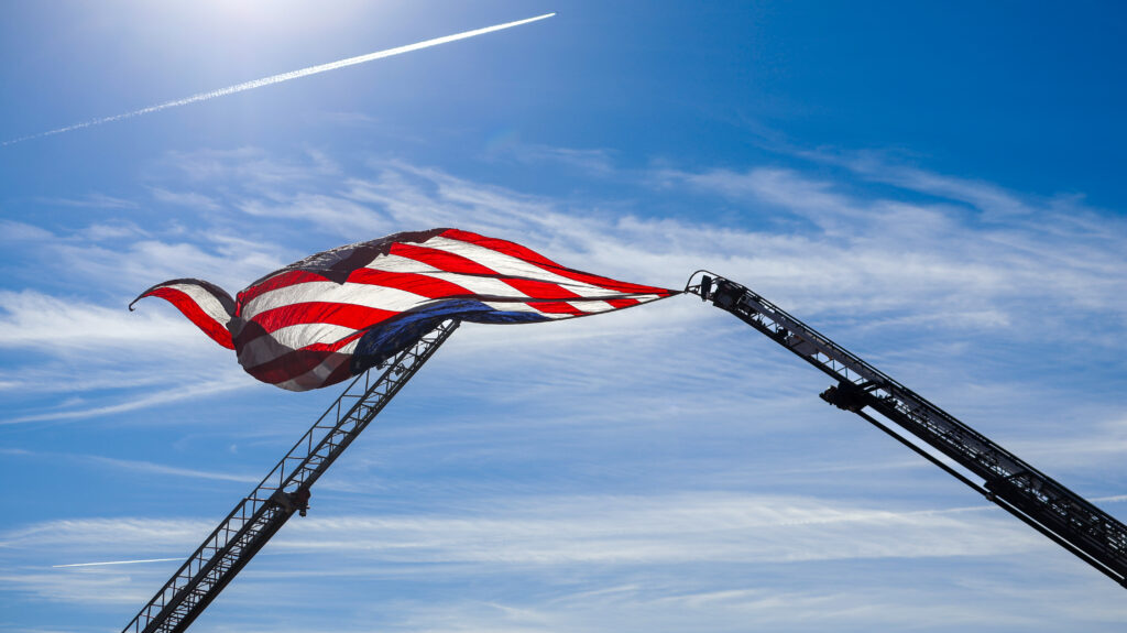 Ladder trucks from Sandoval County Fire Rescue and Bernalillo County Fire and Rescue prepare to fly the flag.
