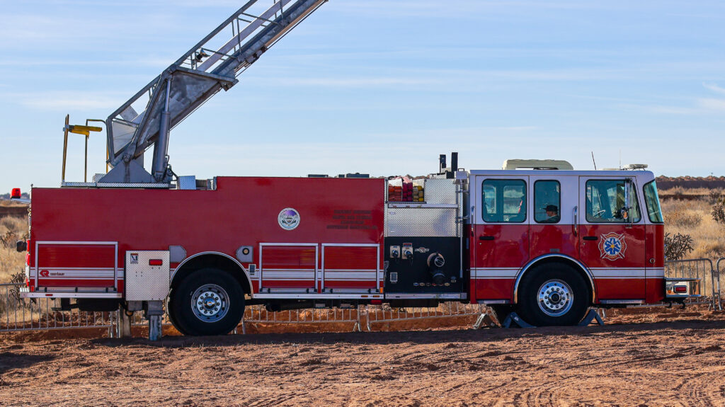 Ladder trucks from Sandoval County Fire Rescue and Bernalillo County Fire and Rescue prepare to fly the flag.