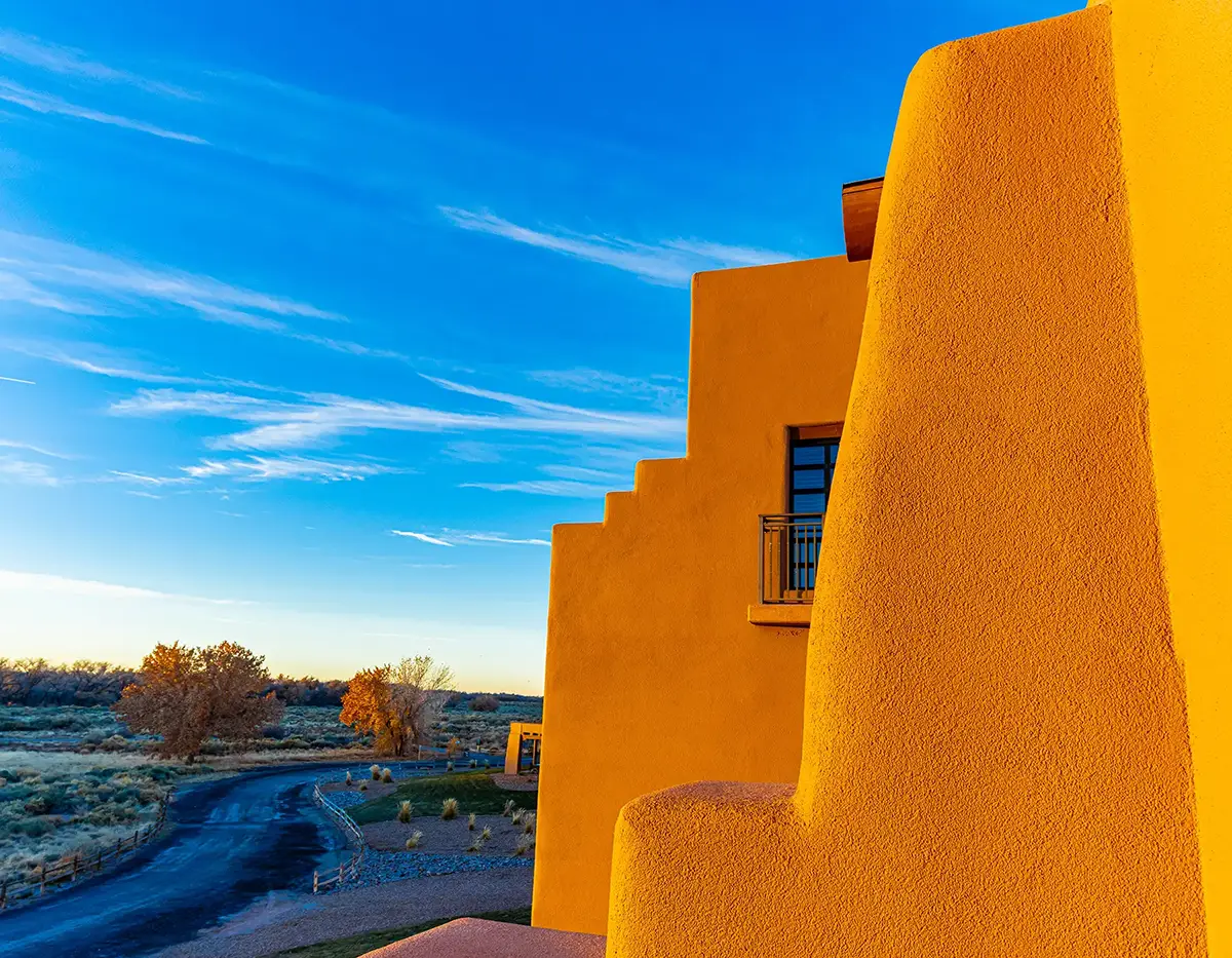 Profile of a vibrant yellow-orange building in the adobe style.