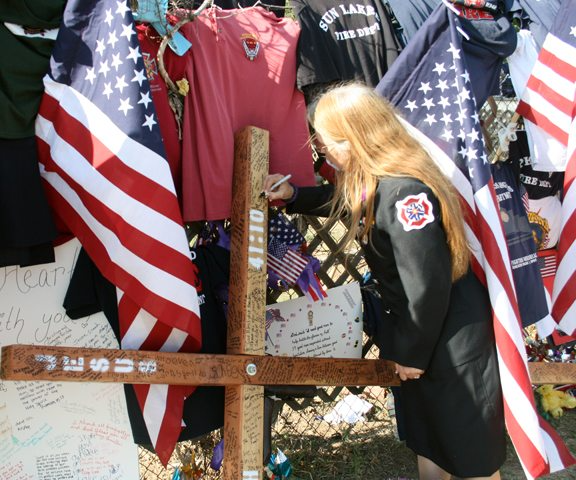 Signing a cross at a firefighter memorial