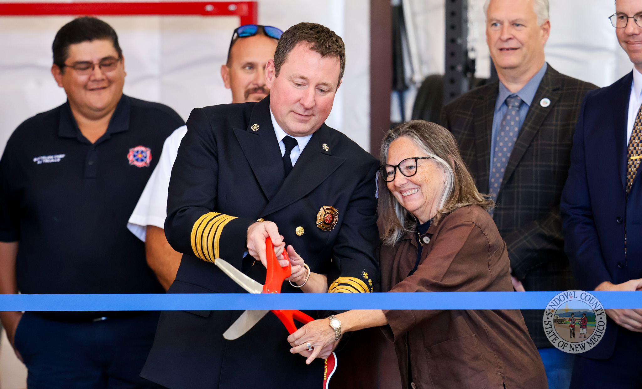 IMG_0435-2 Commissioner Katherine A. Bruch and Fire Chief Chris Bagley cut the ribbon for Fire Station 34 Cuba-NW! Back row, from right: Deputy County Manager Eric Masterson; County Manager Wayne Johnson; Anthony Leyba, State Fire Marshal’s Office; and AJ Trujillo, Chief, District 3 Volunteer Fire Station.